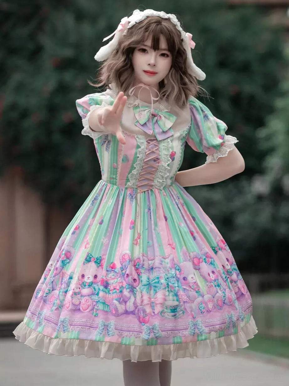 Sweet lolita dress front three-quarter view with pastel stripe print, cartoon floral hem, ruffled puff sleeves, and lace-up bodice worn with bunny ear hair accessory in outdoor park setting