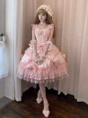 Full front view of pink sweet Lolita dress featuring decorative silk bows, lace-trimmed tiered skirt, modeled with long lace gloves and flower hair accessory in indoor setting