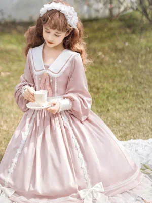 Pink sweet lolita one-piece dress front full view with lace skirt trims and white-trimmed sailor collar held by model with tea set
