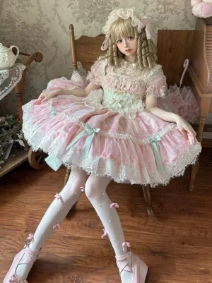 Pink sweet lolita dress three-quarter view sitting pose showing ruffled lace skirt mint bow stockings and puff sleeves