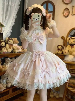 Pink and white sweet lolita princess dress front view with flower hair accessory, ruffled cuffs and delicate lace trims, modeled by twin-tailed girl in vintage doll room