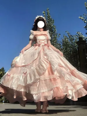 Pink and white sweet lolita dress front full-body view outdoors with blue sky, puff short sleeves, layered ruffled skirt, pink satin trims, romantic fairy tale aesthetic
