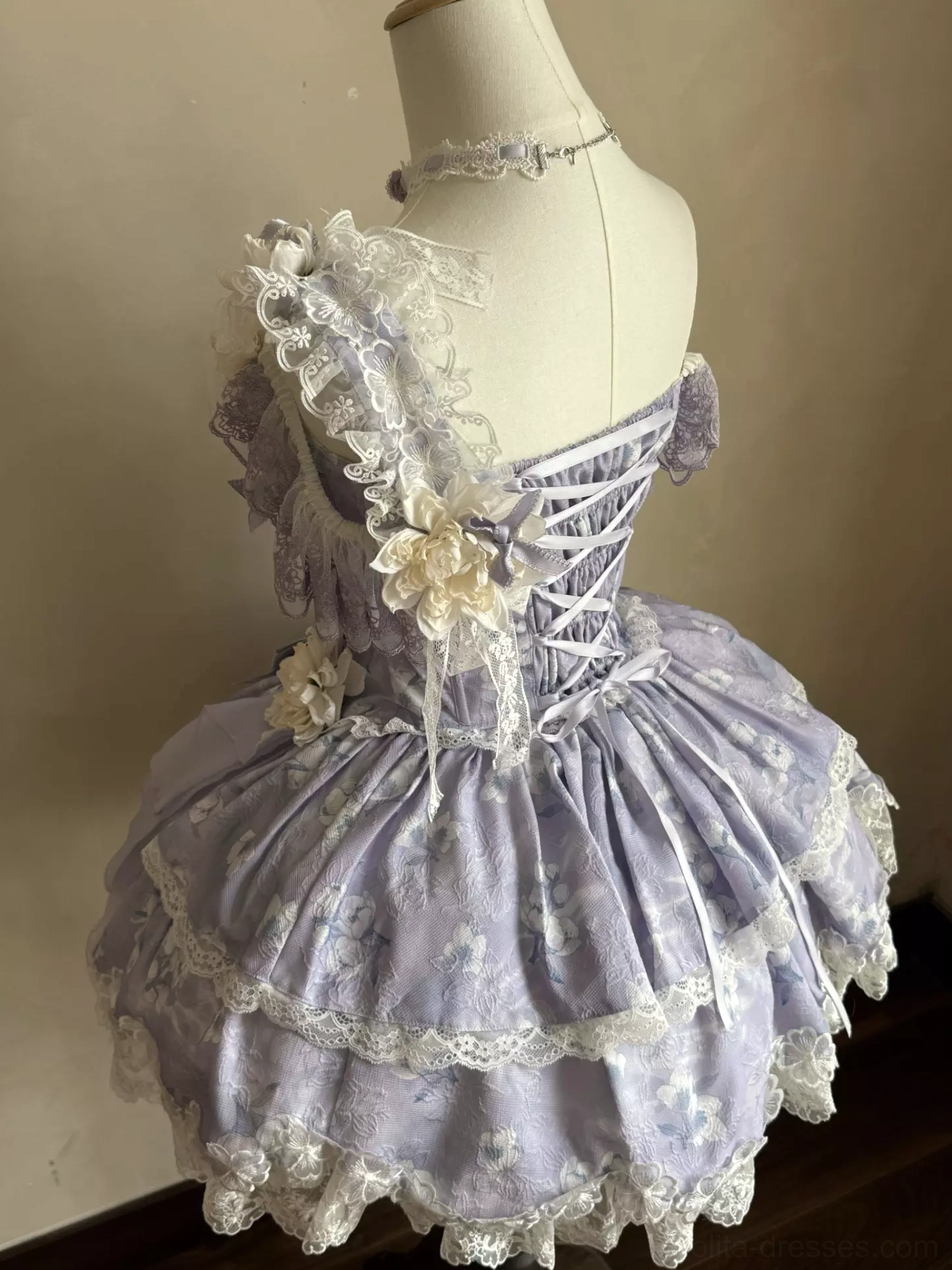Back view of purple sweet lolita corset dress showing lace-up corset back ruffled shoulder and layered lace skirt construction