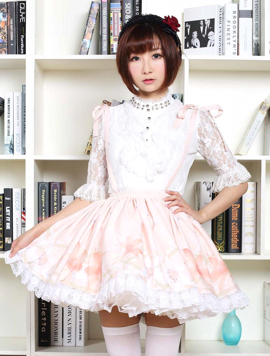 Sweet lolita pink printed dress three-quarter front view with pearl choker and ruffled lace skirt hem