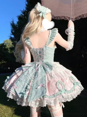 Sweet lolita fairy dress back view with large bow lace-up corset back detail ruffled hem on blonde model lawn garden background