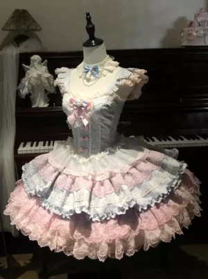 Sweet lolita dress three-quarter front angle showing ruffled cap sleeves delicate lace bodice and voluminous tiered ruffled skirt with piano backdrop