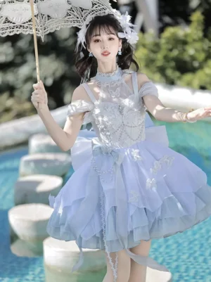 Enchanted light sky blue lolita dress front view poolside with model holding white lace parasol displaying large back bow and voluminous tiered tulle skirt with beaded bust details