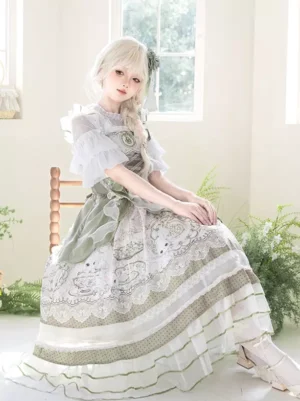 Sweet Lolita fairy dress in sage green and white with matcha-toned ruffle sleeves and lace-trimmed bunny floral printed jumper skirt, seated model front view