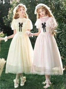 Two models wearing sweet lolita fairy dresses with and without lace capelet, front full-body view with black bow neckties in garden
