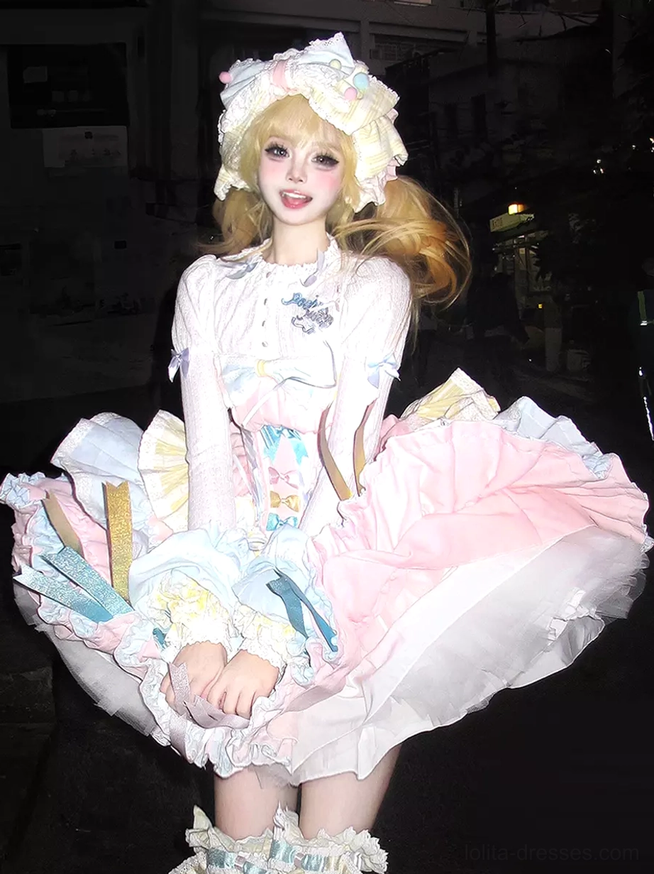 Sweet Lolita fairy tale JSK dress 5-piece ensemble front view blonde model squatting pose pink blue white multi-layered ruffles matching hair bonnet