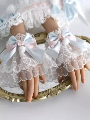 Sweet Lolita fingerless lace gloves with pink and blue satin bows featuring fuzzy pompoms, worn on mannequin hands with rococo-inspired embroidered white lace detailing and scalloped edges