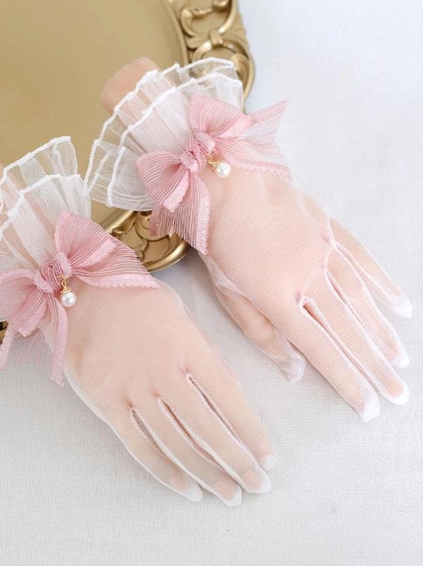 Dusty rose pink sheer mesh lolita gloves with pearl bow and ruffled cuffs close-up detail shot