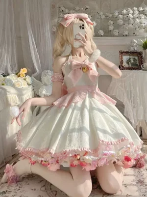 Sweet Lolita halter neck dress in pink and white with golden bell bow, rear three-quarter view showcasing ruffled floral skirt hem, pink arm cuffs and vintage studio setting