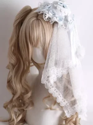 Sweet Lolita headdress featuring light blue satin bows and white lace veil with sparkly tulle embellishment, displayed on mannequin with blonde twin-tail wig, Rococo-inspired hair accessory for fashion meetups and cosplay events
