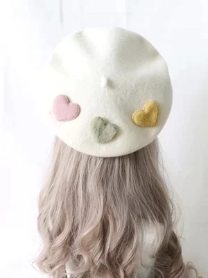 White lolita beret back view with three pastel heart decorations on curly blonde mannequin