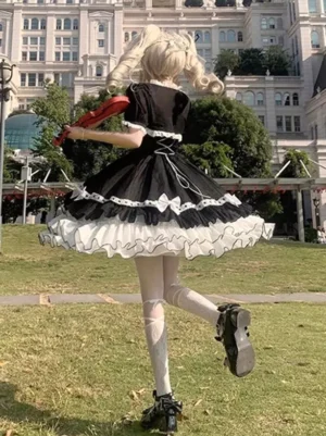 Back view of lolita JSK dress showing lace-up back design and cascading ruffled skirt hem with black-white color matching detail
