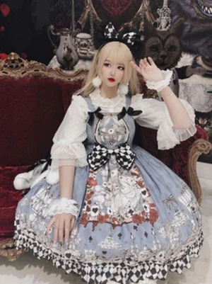 Sweet lolita JSK dress seated pose on vintage red velvet sofa showcasing white ruffled inner shirt lace-trimmed puff sleeves and black-white checkered bow details