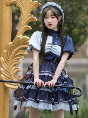 Sweet lolita stand collar jumper dress full front view with color block bodice, buttoned front closure, and multi-tiered ruffle skirt outdoor golden railing backdrop