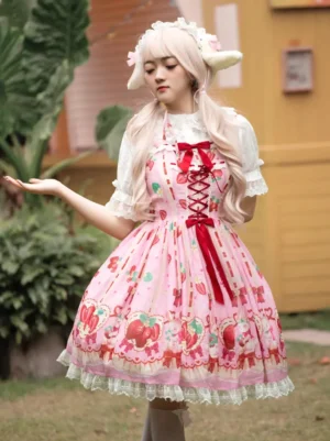 Sweet Lolita jumper skirt dress three-quarter angle displaying red front ribbon detail, ruffled inner sleeves, and printed strawberry rabbit motif on pink fabric