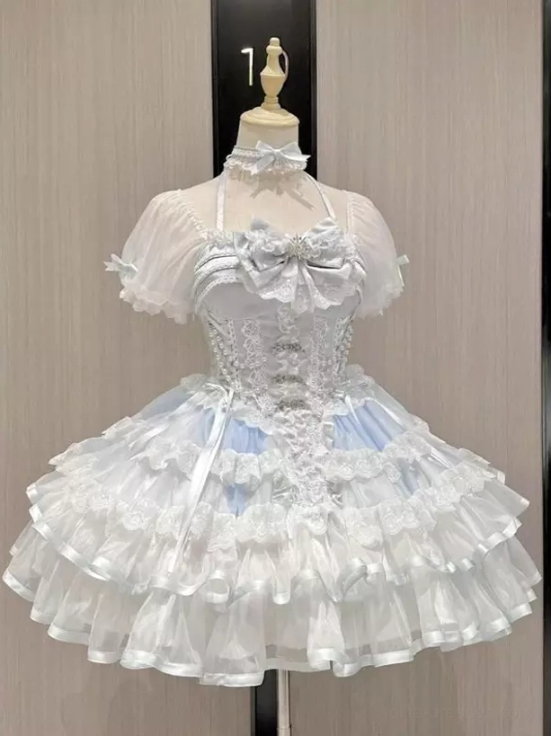 Sweet lolita JSK dress on mannequin front studio view showcasing corset bodice short puff sleeves tiered ruffle skirt and matching choker accessory