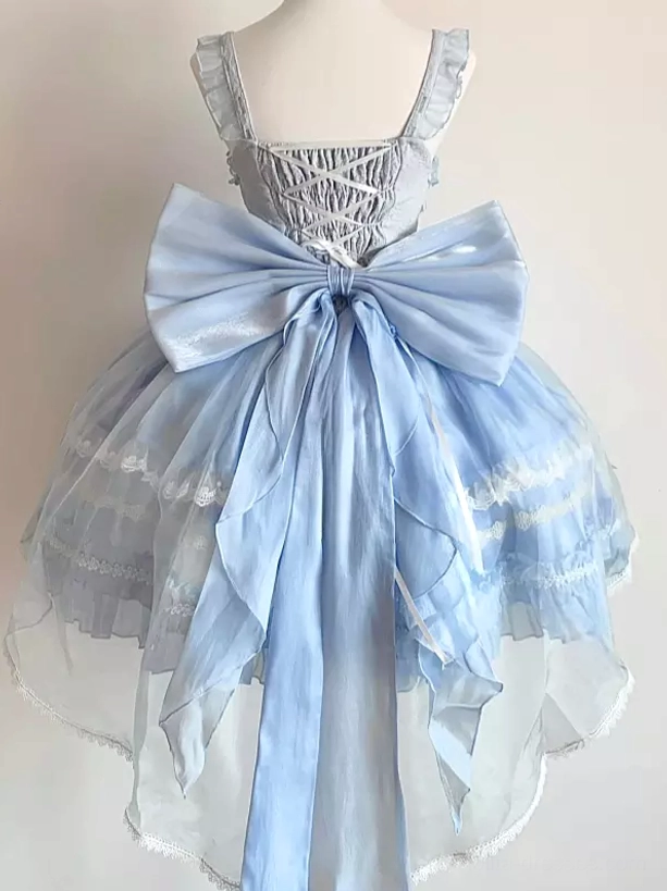 Light blue lolita JSK dress back view with oversized satin bow, lace-up corset back, and flowing layered tulle skirt on mannequin