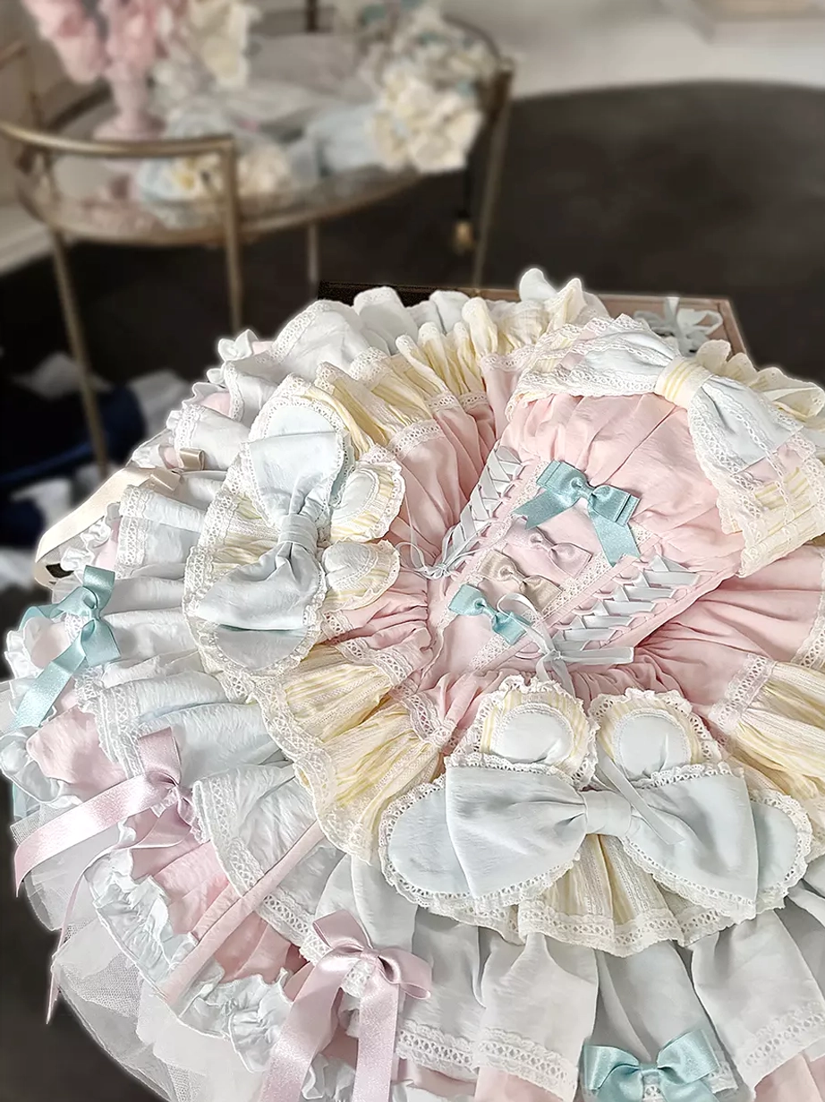 Lolita JSK skirt detailed top-down close-up circular ruffled design blue bow details pastel color palette indoor table setting layered construction