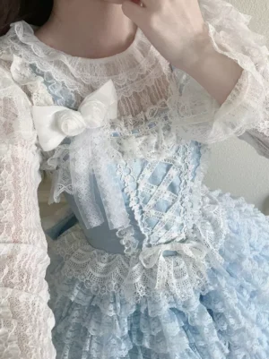 Close-up detailed view of sweet lolita dress bodice featuring cross-lace front panel ruffled lace trim and white rose bow accent on light blue hime lolita jumper