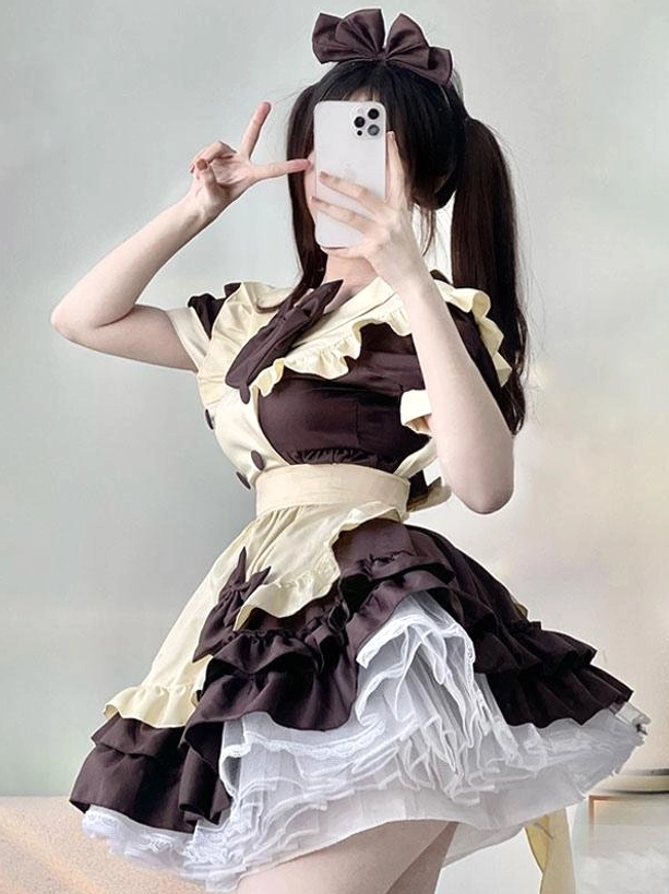 Sweet Lolita maid dress in coffee brown and beige with tiered ruffled skirt, puff short sleeves, and oversized hair bow - front view on model