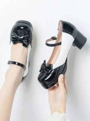 Two-tone sweet Lolita chunky heel shoes held in hands, featuring bow ornament and adjustable Mary Jane ankle strap with buckle detail