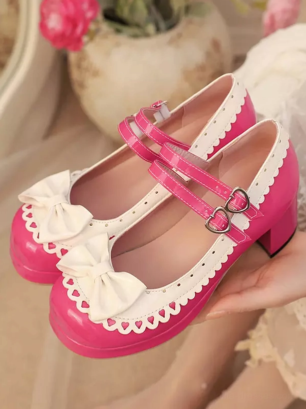 Close-up overhead view of glossy hot pink sweet lolita mary jane shoes with scalloped trim details held in human hand, showcasing pu leather finish quality