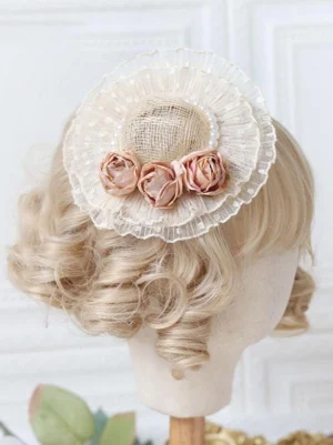 Sweet Lolita mini fascinator hat with dusty pink rose ornaments and pearl trims on blonde doll mannequin head, back upper side view showing beige mesh base construction and elegant embellishment details