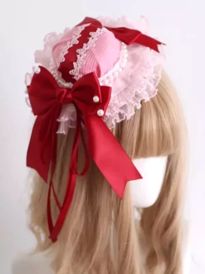 Sweet Lolita mini hat headdress with pink-white ruffled lace and wine red satin bow featuring pearl accents, shown on mannequin from rear angle with light brown bangs wig displaying intricate layered lace design and pearl ornament details