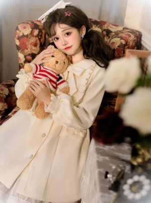 Lolita wool overcoat three-quarter side profile view showing waist strap and ruffled collar trim on model leaning on floral sofa