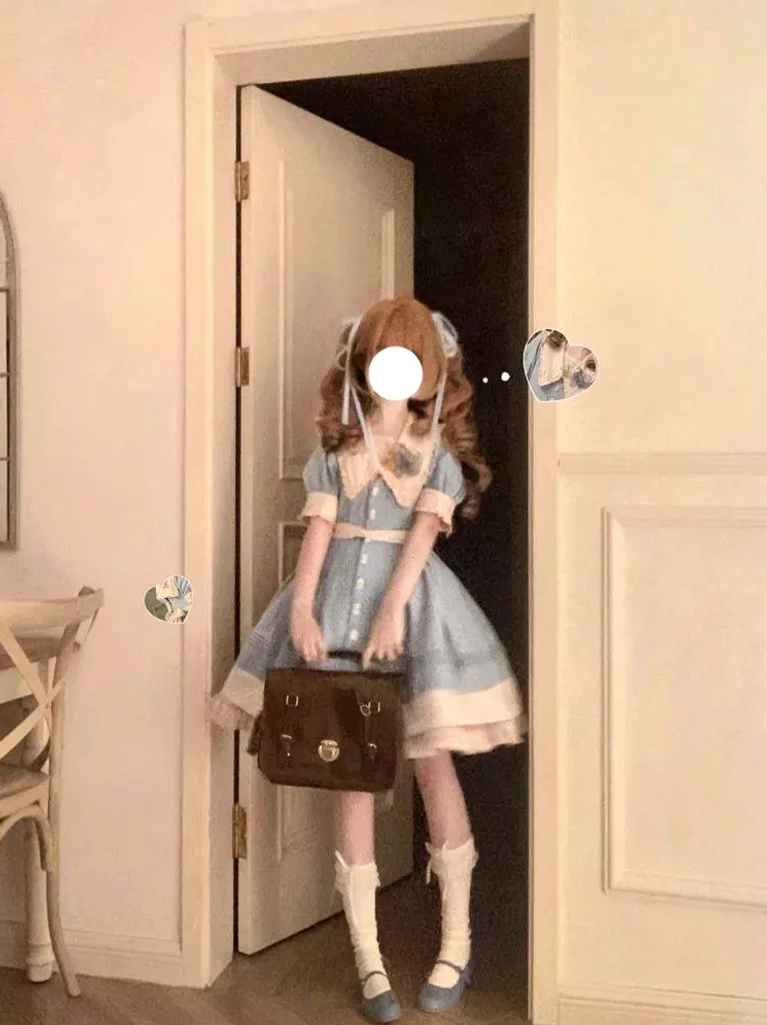 Full body standing indoor view of Sweet lolita dress with light sky blue and ivory coloring, female model with curly hair and masked face holding vintage brown leather bag, Peter Pan collar, short puff sleeves, white socks and shoes coordinate