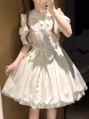 White sweet lolita mini dress with peter pan collar and cold-shoulder puff sleeves front three-quarter view on model indoor setting with lace-trimmed skirt hem and waist bow sash detail