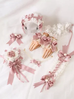Complete Sweet Lolita pink accessories set featuring matching choker, wrist cuffs, and hair accessories with ruffled white lace, dusty pink satin bows, floral ornaments, and pearl accents, displayed as coordinated flat lay on white fabric
