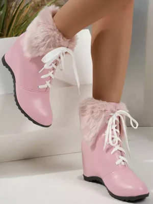 Blush pink lolita ankle boots side profile showing low wedge heel white shoelaces fuzzy pink fur trim architectural background