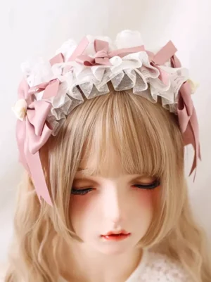 Sweet lolita pink bow headdress with ruffled white lace and rose ornaments worn on blonde doll mannequin front view