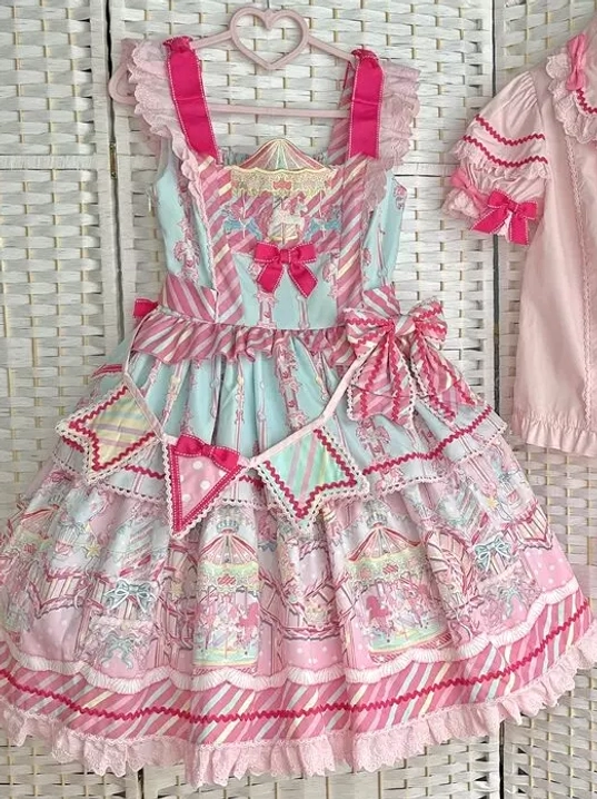 Close-up front detail shot of sweet lolita dress showing ruffle front bows, decorative elements, and cartoon print details on wearer