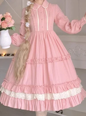 Three-quarter front view of pink sweet lolita dress showing buttoned placket, lantern sleeves, layered lace hem, and classic lolita silhouette in studio setting with vintage aesthetic