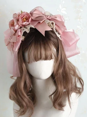 Sweet Lolita pink bow headdress front view featuring dusty pink peony-inspired flowers and beige lace edging displayed on mannequin, showcasing the romantic floral design and bow embellishments characteristic of authentic Lolita headwear accessories