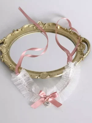 Full front view of sweet lolita heart choker showing pearl-bordered pink heart gemstone pendant and elegant white lace ruffle trim with satin bow accent on antique gold decorative tray