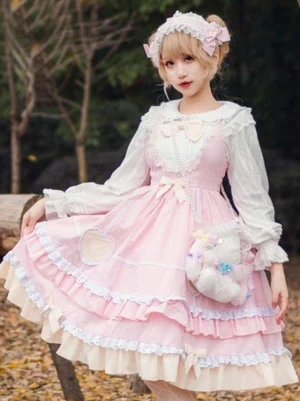 Sweet lolita pink jsk dress with heart appliques and multi-layered ruffles front view outdoor natural setting
