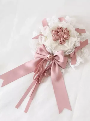 Sweet Lolita pink lace headdress with satin bows and rose decorations, dusty pink and off-white color scheme, flat lay overhead view on white background, delicate fabric embellishments