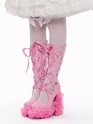 Sweet Lolita pink patent leather platform boots direct front view showcasing full criss-cross ribbon lacing system and ruffled platform sole, paired with white lace skirt and sheer stockings