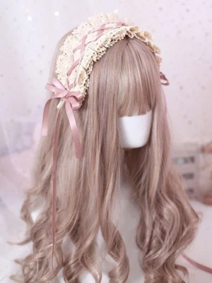 Sweet Lolita pink ribbon ruffled lace headdress with silk bow and cascading streamers on light brown wavy wig, three-quarter front view demonstrating elegant bow tie detail