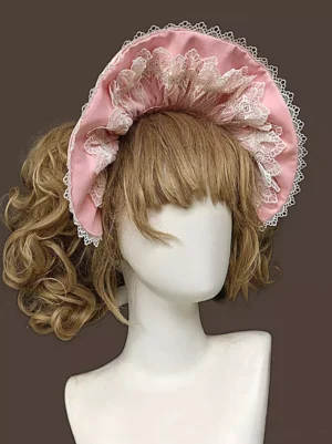 Sweet lolita ruffle bonnet hat with pink sateen fabric and white lace ruffled trims shown on blonde curly-haired mannequin from front three-quarter view angle