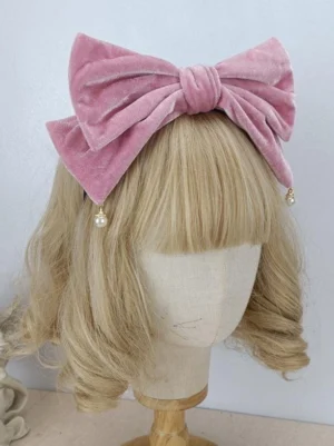 Sweet Lolita pink velvet pearl bow headdress front view on mannequin with curly blonde wig, showing delicate pearl drop decoration and ornate rococo-inspired design