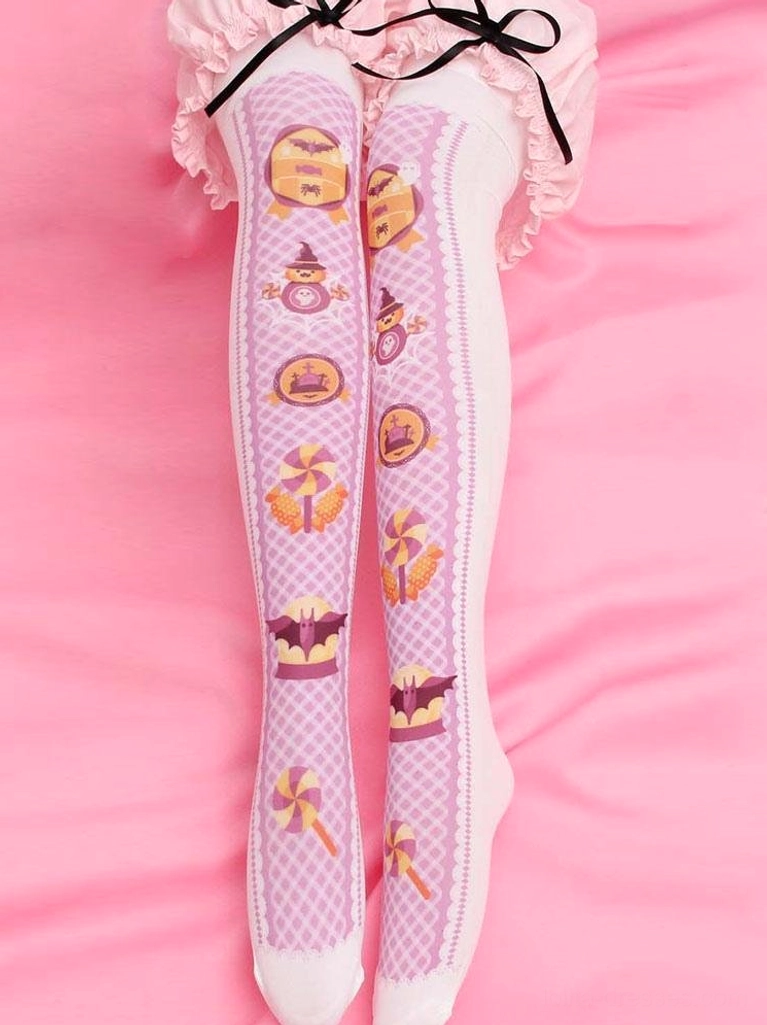 Sweet Lolita pink velvet thigh-high stockings with white lattice pattern and spooky cute prints including tombstones lollipops and bats, worn with pink frilly skirt in full leg view