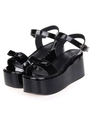 Sweet lolita platform sandals with high wedge heel, ankle strap buckle, and front bow detail in classic black patent leather - top front pair view